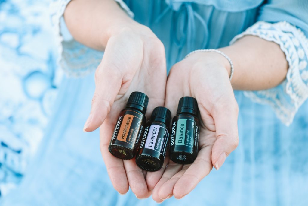womans hands holding essential oils