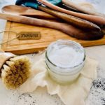 Jar of Spoon Butter and wood brush and spoons cutting boards