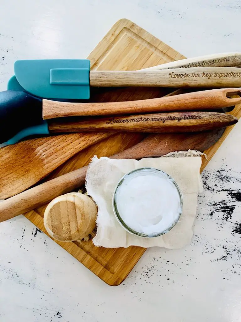 wood spoons and cutting board with jar of spoon butter on table
