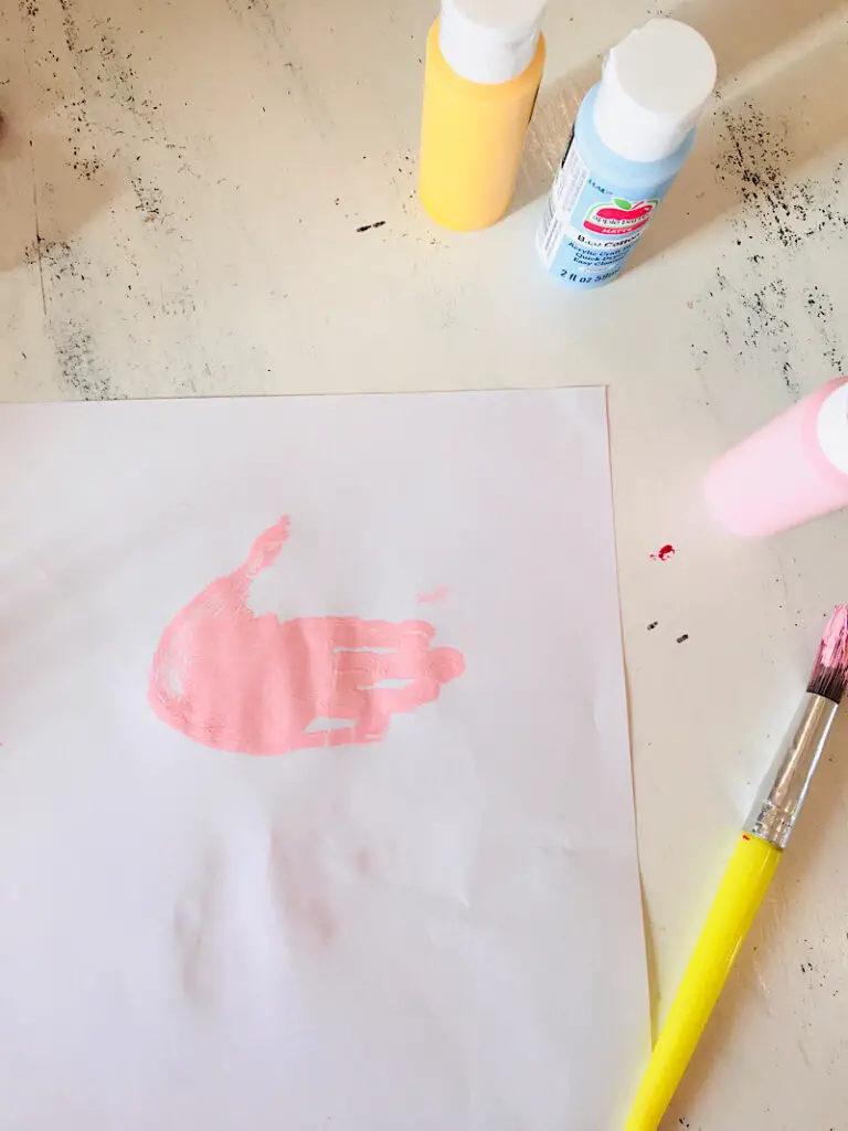 Pink handprint on paper to make a unicorn
