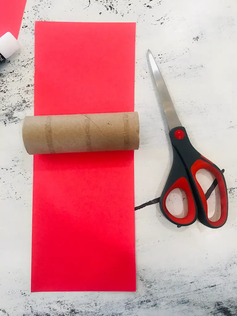 cutting out paper to cover a toilet paper tube for a firework craft