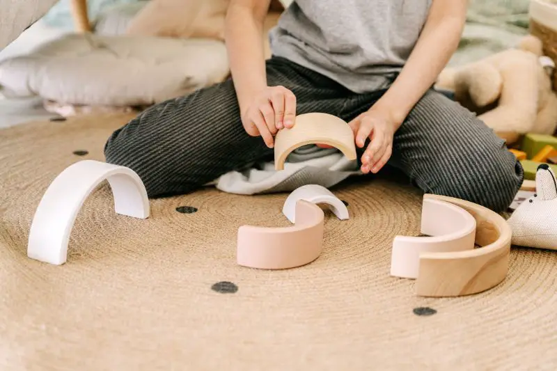 child playing with wooden toys