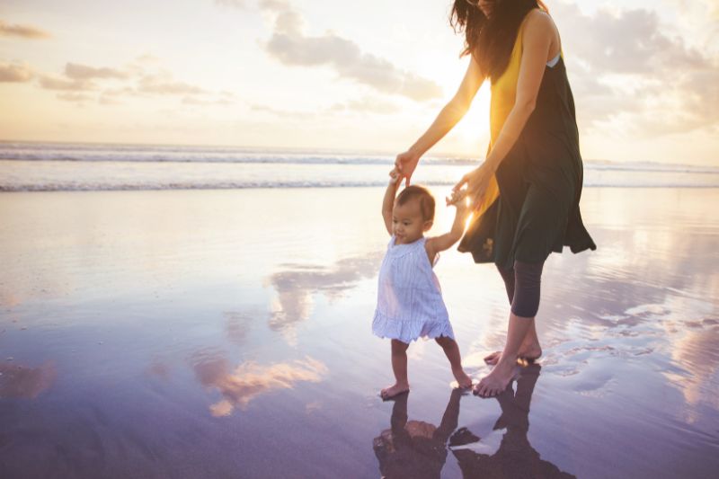 mother and child walking on beach